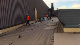 Workers applying commercial roofing and siding